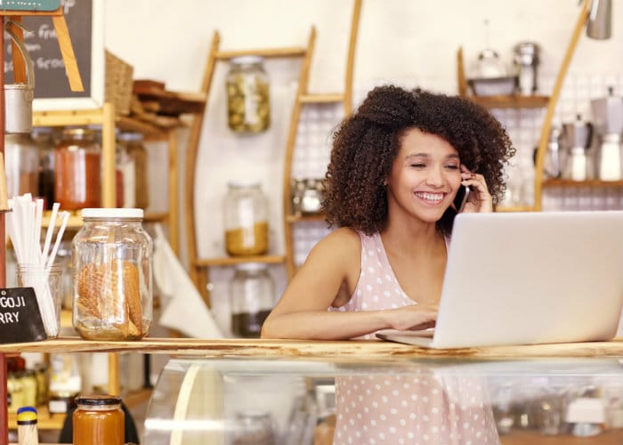 Woman Working on Laptop in Shop