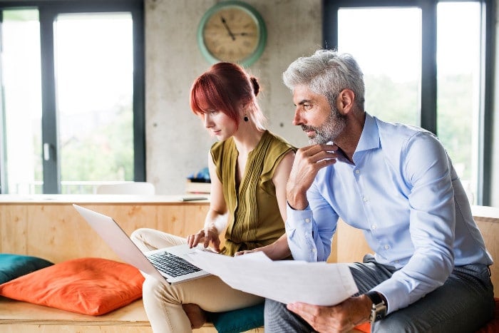 Man and woman collaborating while looking at laptop