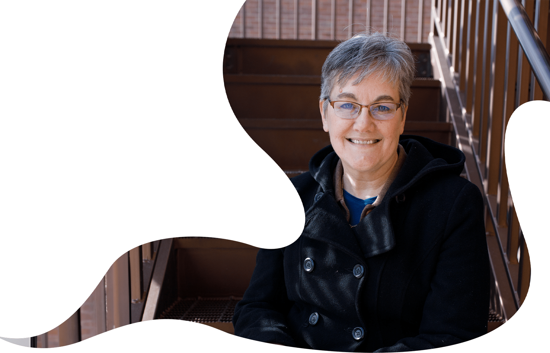 Karen Ingle, Freelance Writer, a woman with glasses, sitting on stairs.