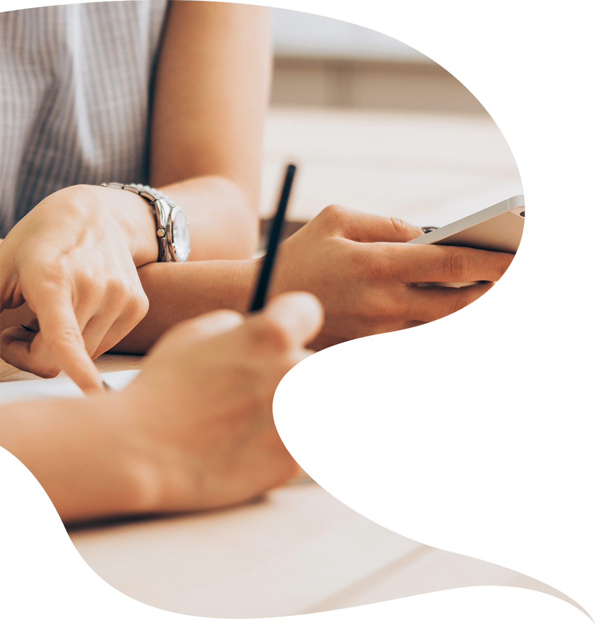 A woman holding a cell phone and writing on a piece of paper