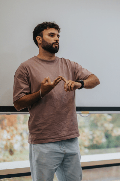 Young bearded man counts off his points on his fingers during speech