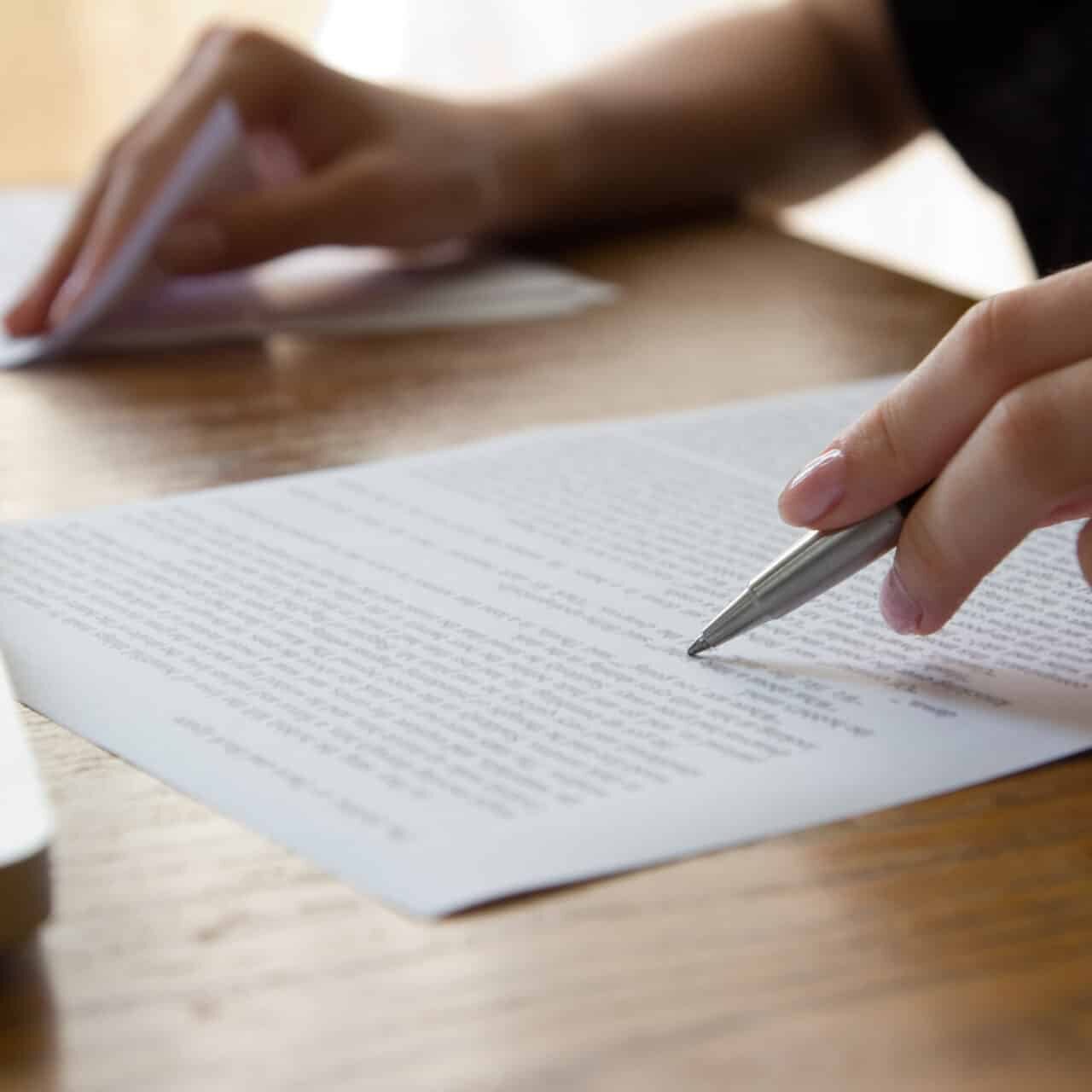 A person editing a piece of paper with a pen.