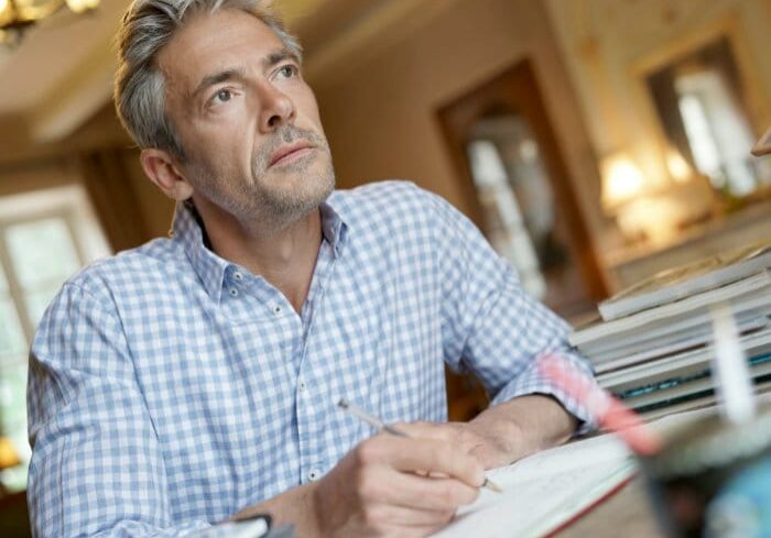 Man Writing and Looking Off in Distance